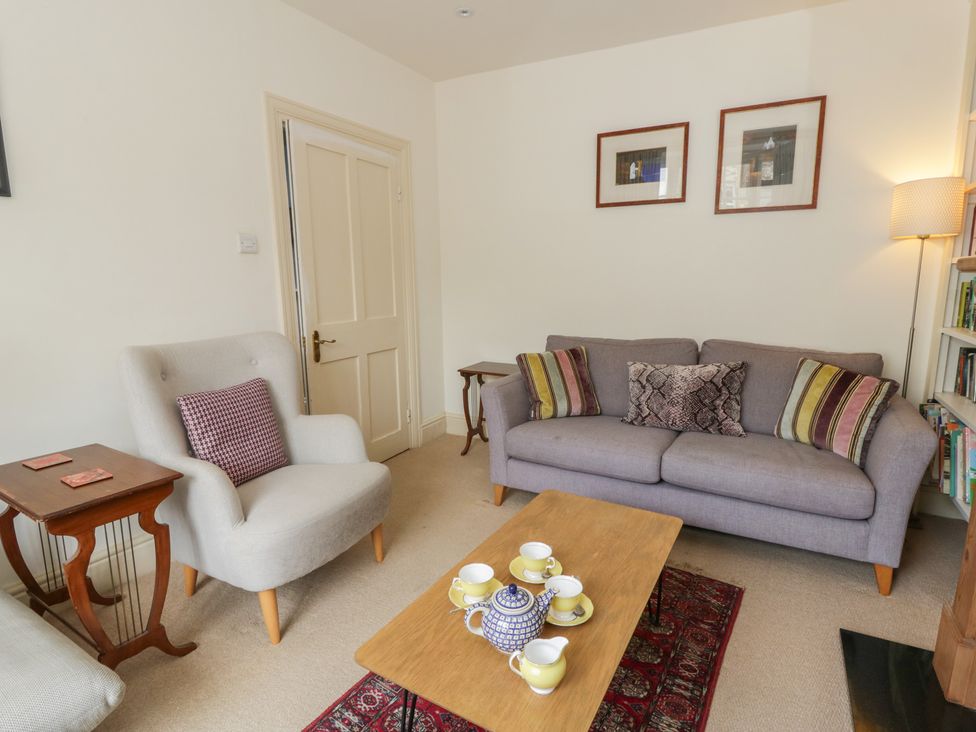 A living room with a sofa, armchair, and coffee table at Ty Clyd in Newport, Pembrokeshire