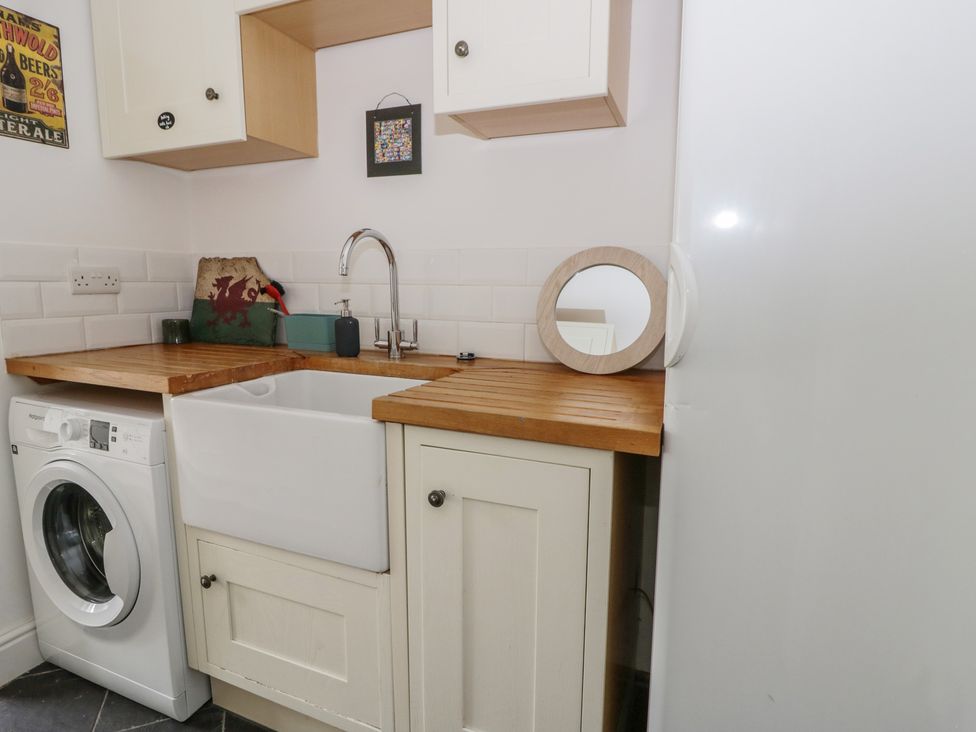 A laundry room with a washing machine and sink at Ty Clyd in Newport, Pembrokeshire
