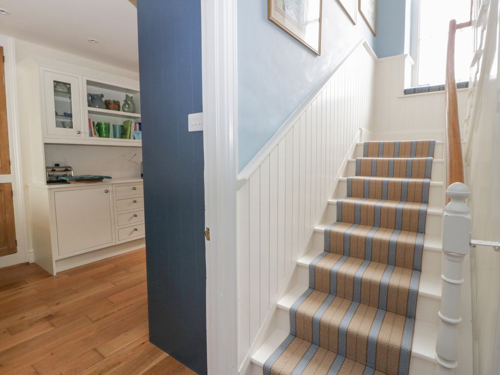 A hallway with stairs and kitchen cabinet at Ty Clyd, Newport, Pembrokeshire