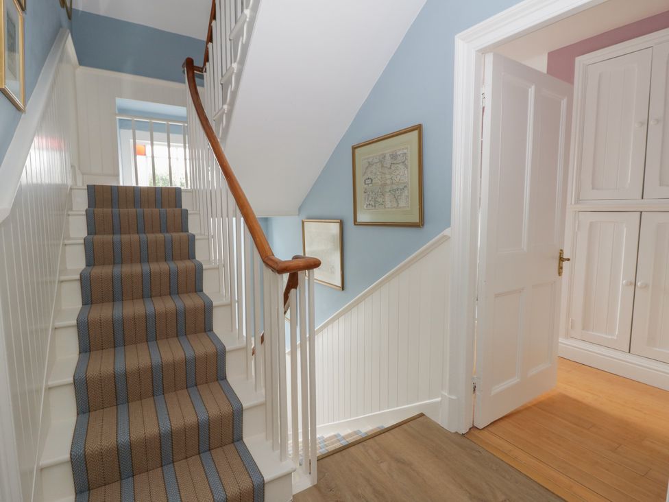 A staircase with handrail and door at Ty Clyd in Newport, Pembrokeshire