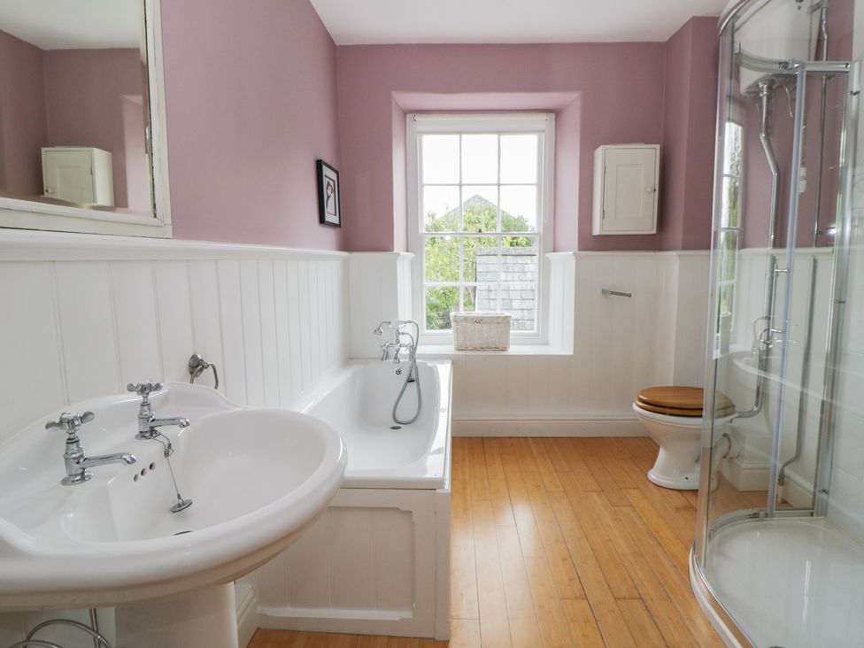 A bathroom with a sink, bathtub, shower, and toilet at Ty Clyd in Newport, Pembrokeshire