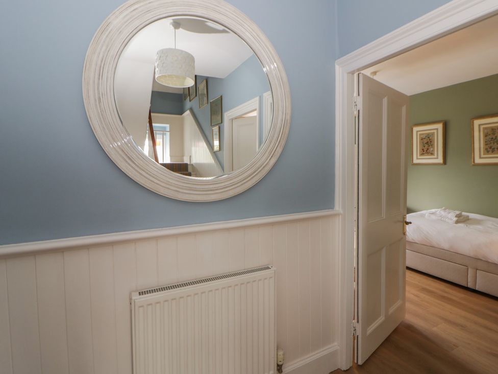 A hallway with a mirror and door at Ty Clyd in Newport, Pembrokeshire