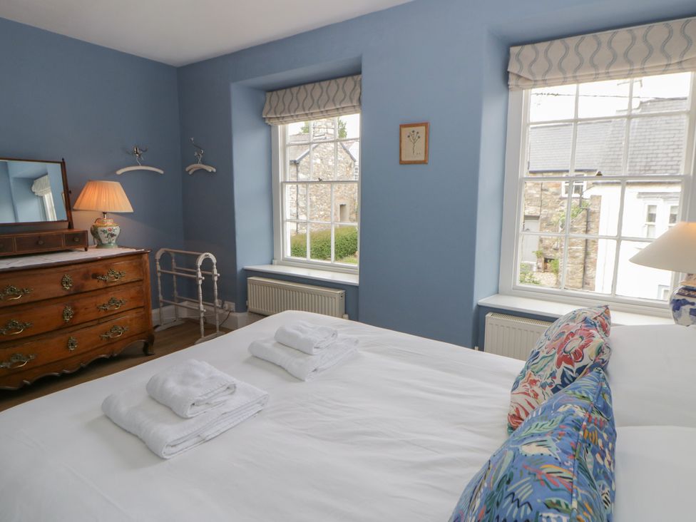 A bedroom with a bed and dresser at Ty Clyd in Newport, Pembrokeshire
