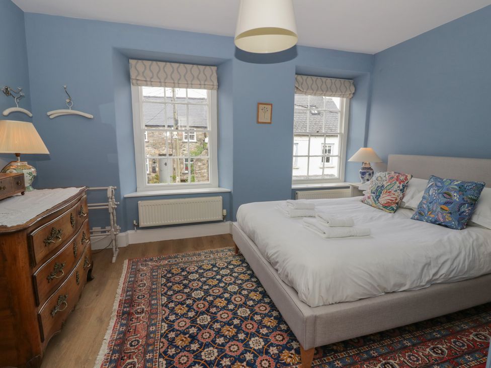 A bedroom with a bed and a dressing table at Ty Clyd in Newport, Pembrokeshire