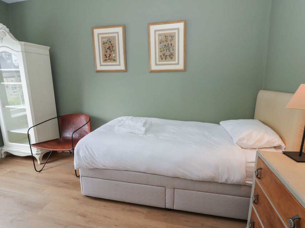A bedroom with a bed and armchair at Ty Clyd in Newport, Pembrokeshire