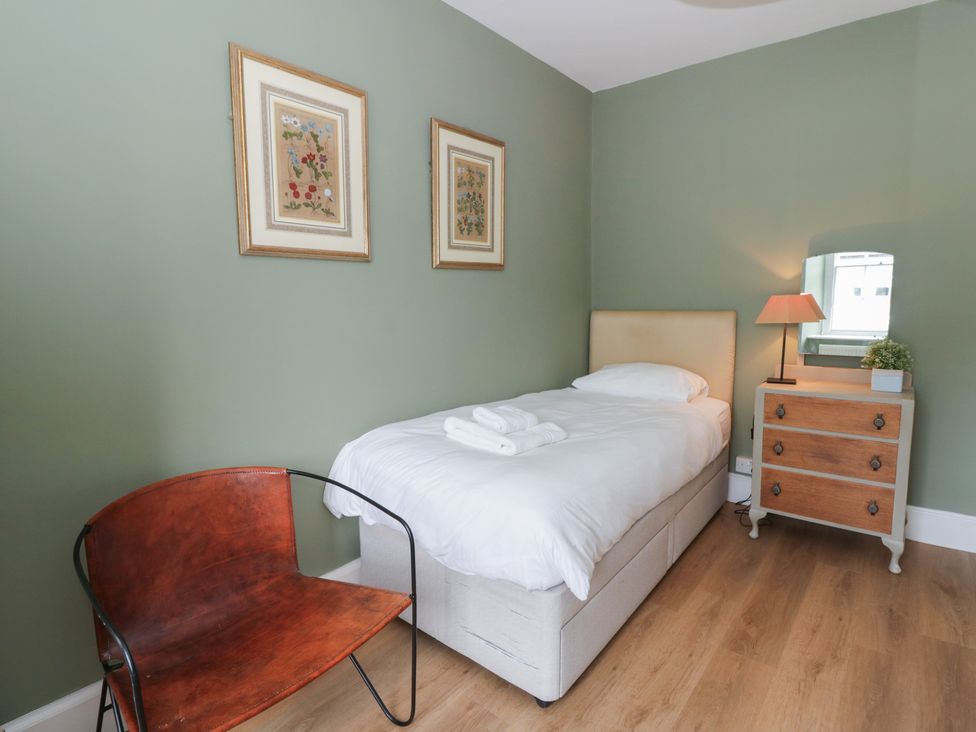 A bedroom with a single bed and a nightstand at Ty Clyd Newport, Pembrokeshire