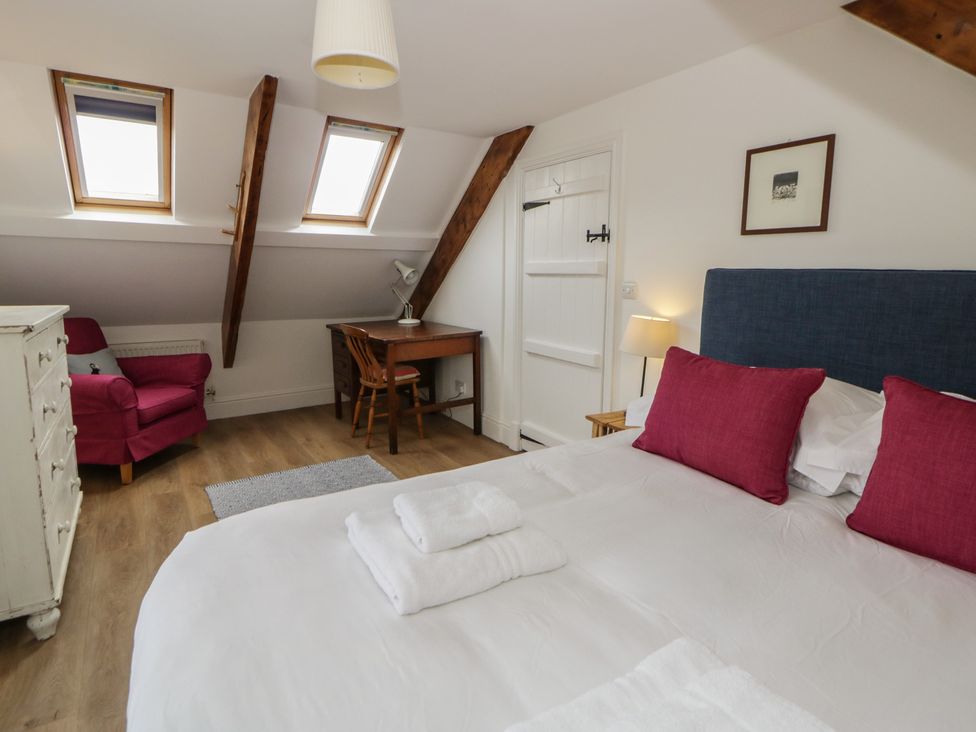 A bedroom with a bed, desk, and seating area at Ty Clyd in Newport, Pembrokeshire