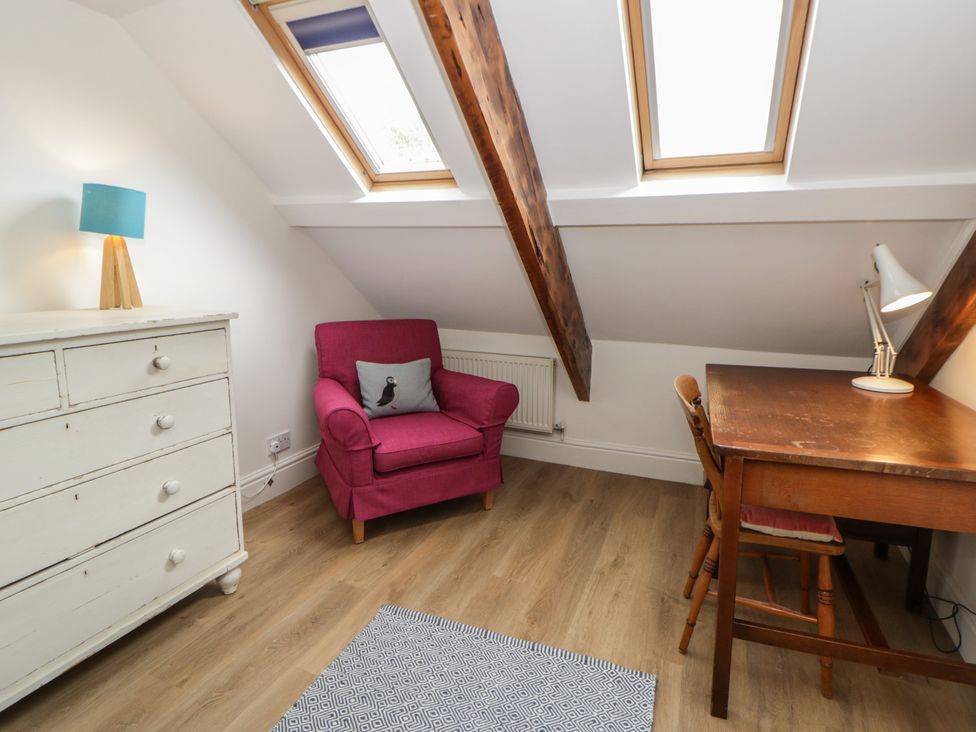 An attic room with a desk and chair at Ty Clyd in Newport, Pembrokeshire