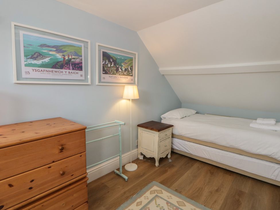 A bedroom with a single bed and furniture at Ty Clyd in Newport, Pembrokeshire