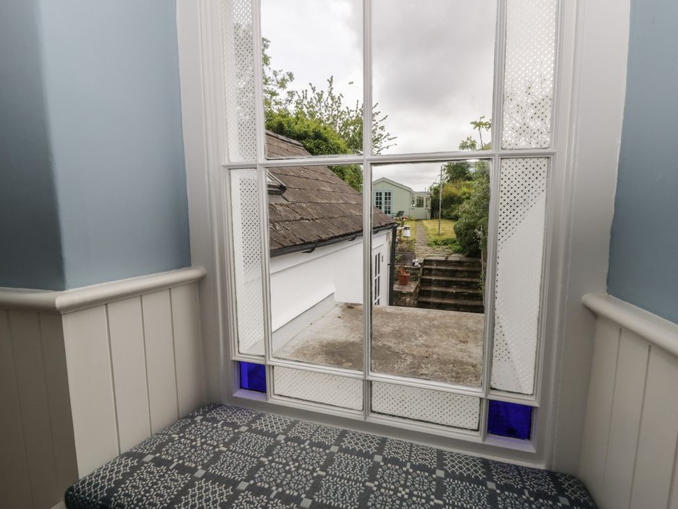 A view from a window with a bench overlooking a garden at Ty Clyd Newport, Pembrokeshire