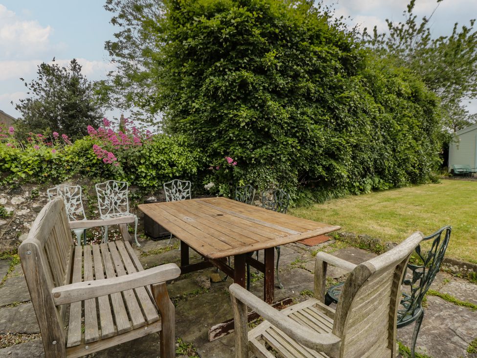 A garden with wooden and metal chairs around a table at Ty Clyd Newport, Pembrokeshire