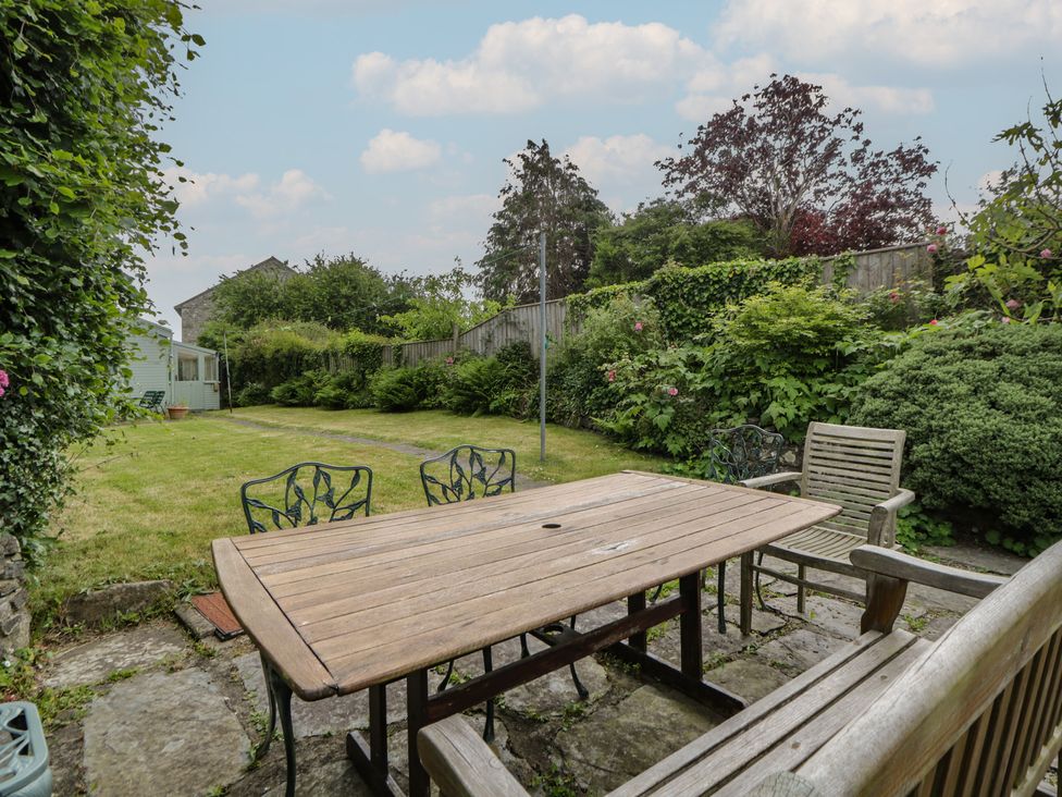 A garden with wooden table and chairs at Ty Clyd Newport, Pembrokeshire