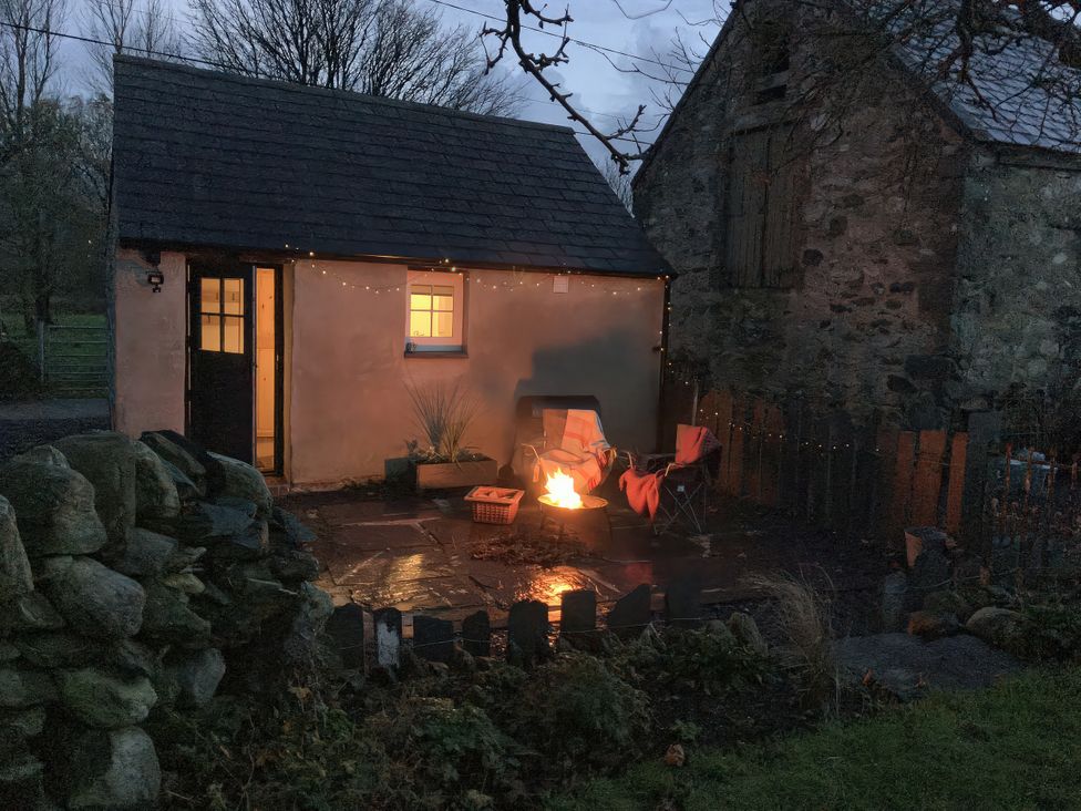 An outdoor setting with a fire pit and chairs at Cwt Mochyn in Llanberis