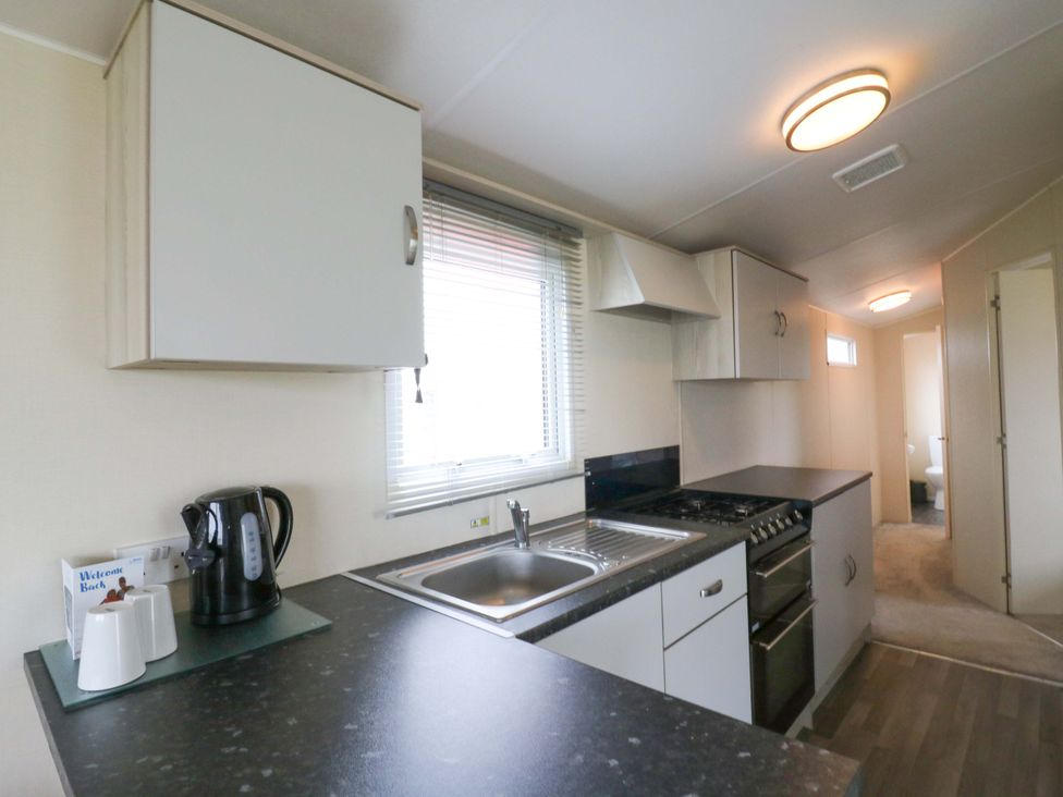 A kitchen with a sink and stove at Meadowside