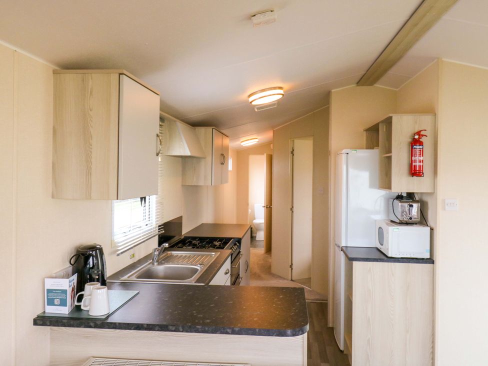 A kitchen with appliances and cabinets at Meadowside