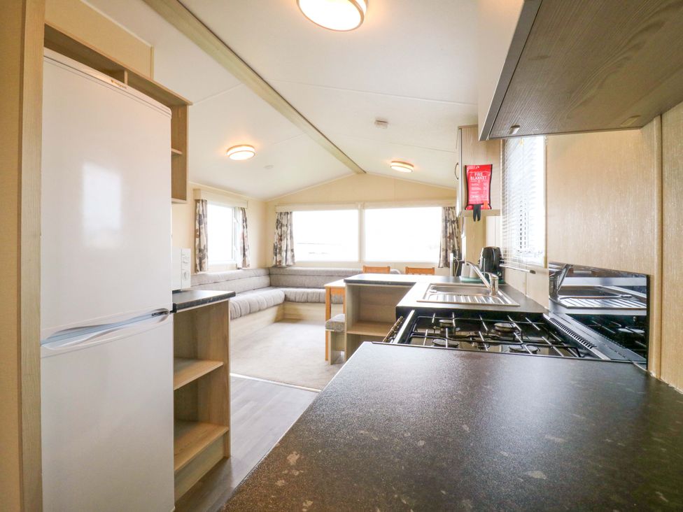 A kitchen with a sofa and dining area at Meadowside in 