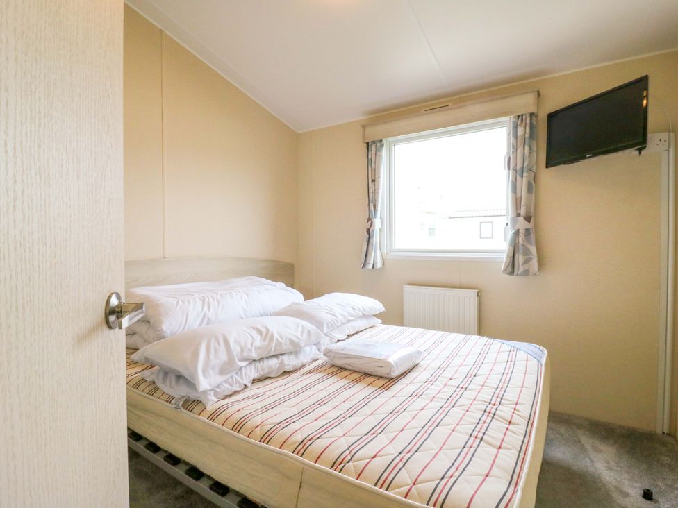 A bedroom with a bed and window at Meadowside