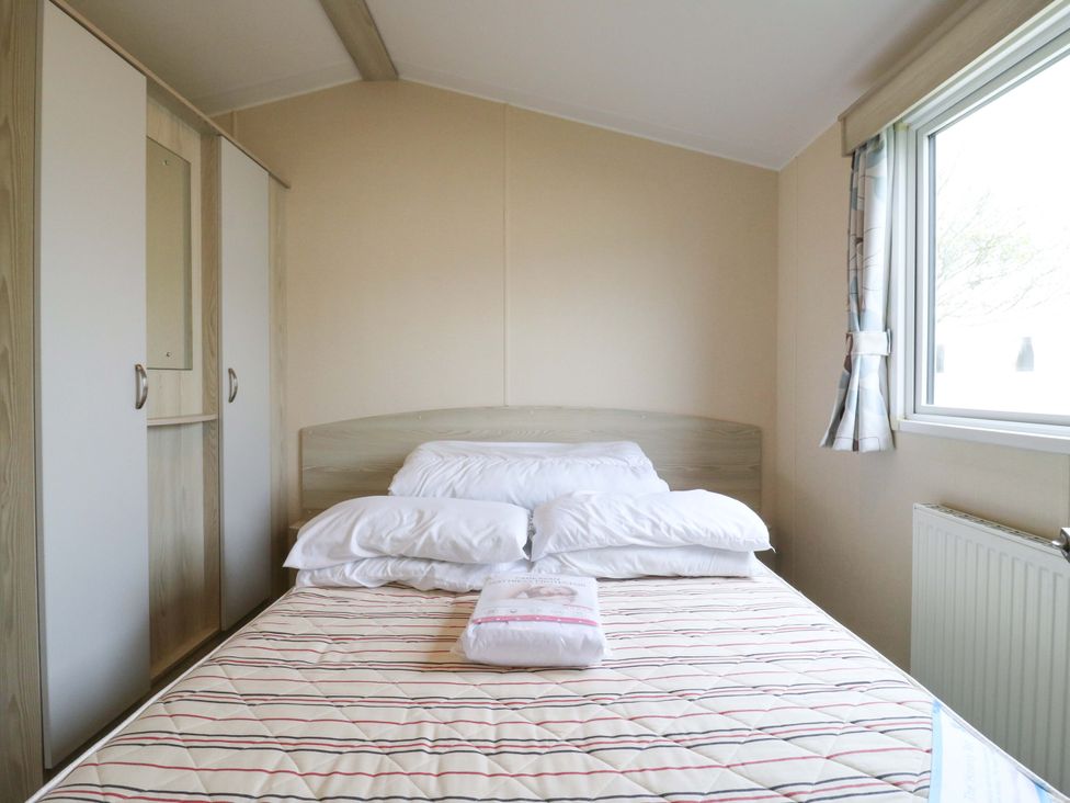 A bedroom with a bed and wardrobe at Meadowside 