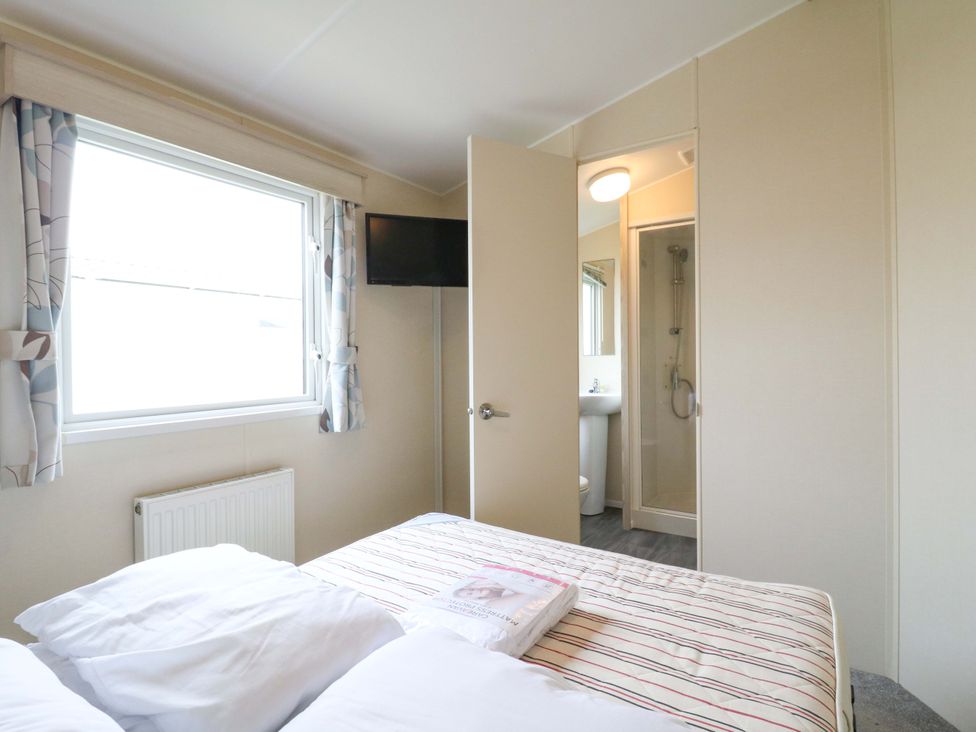 A bedroom with a bed and a bathroom visible at Meadowside