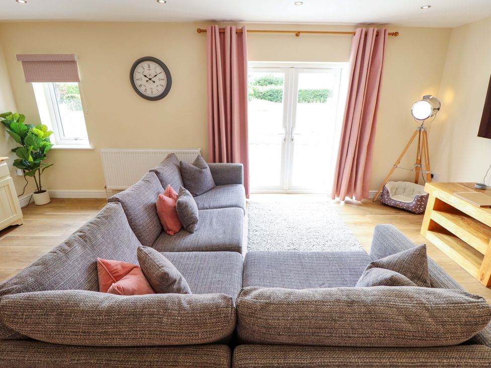 A living room with a sofa and a table at Denholme in Hogsthorpe