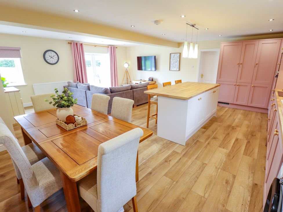 A kitchen with a dining area and living area at Denholme in Hogsthorpe