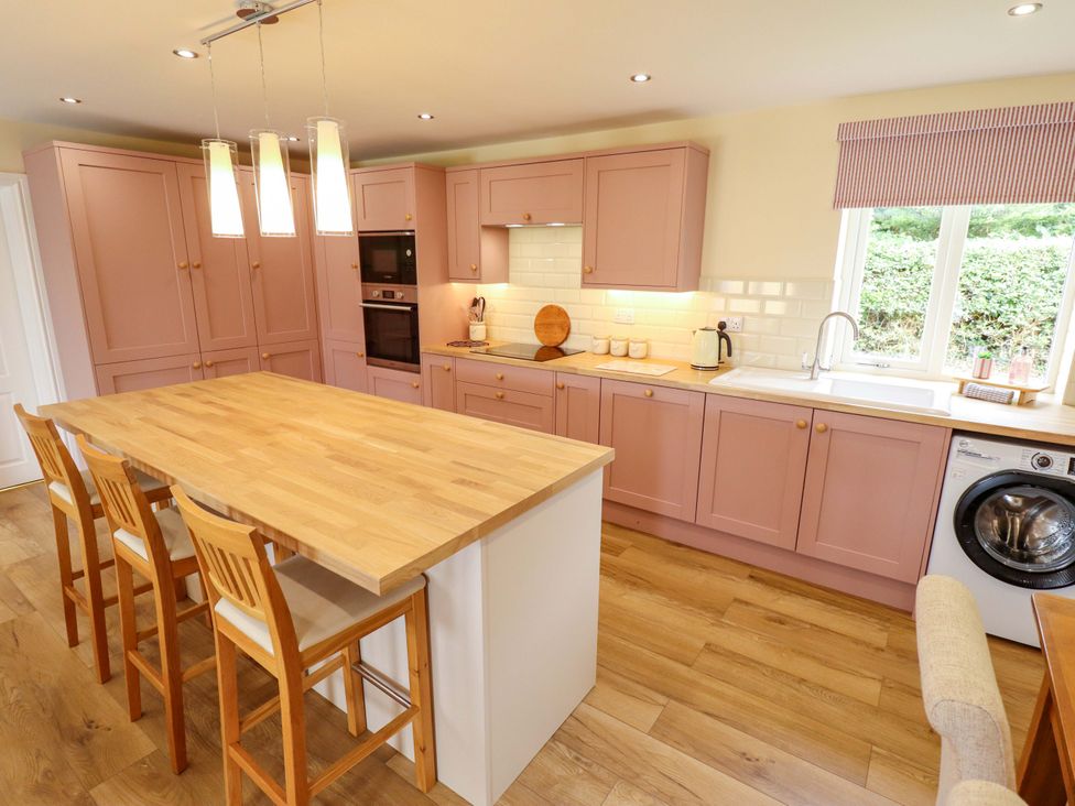 A kitchen with a central island and appliances at Denholme in Hogsthorpe