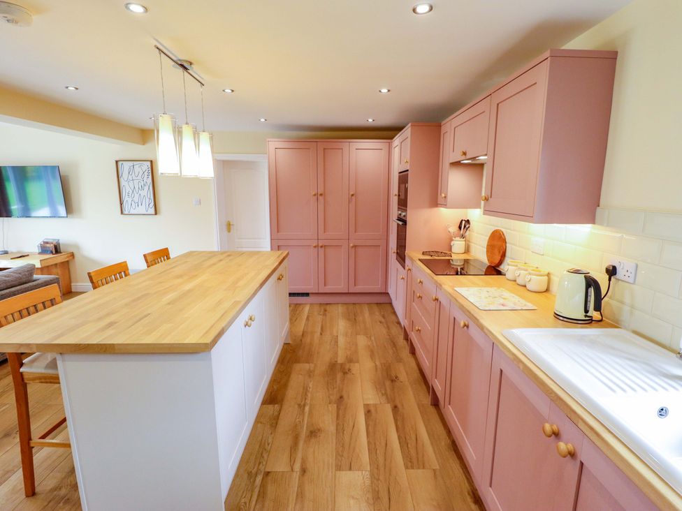 A kitchen with an island and appliances at Denholme in Hogsthorpe
