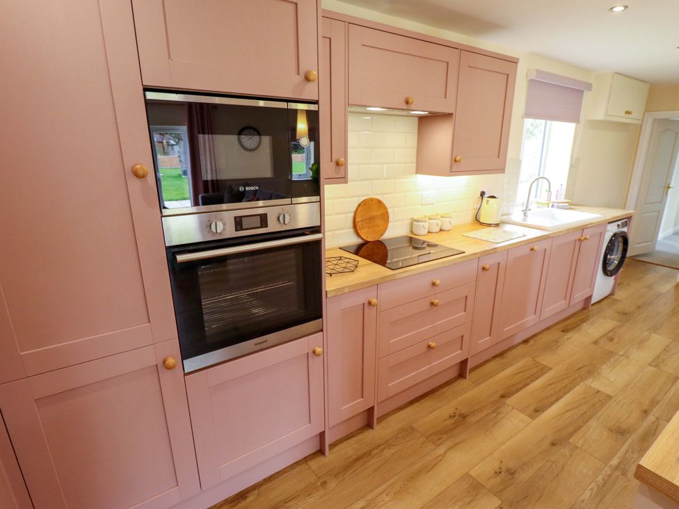 A kitchen with cabinets and appliances at Denholme in Hogsthorpe