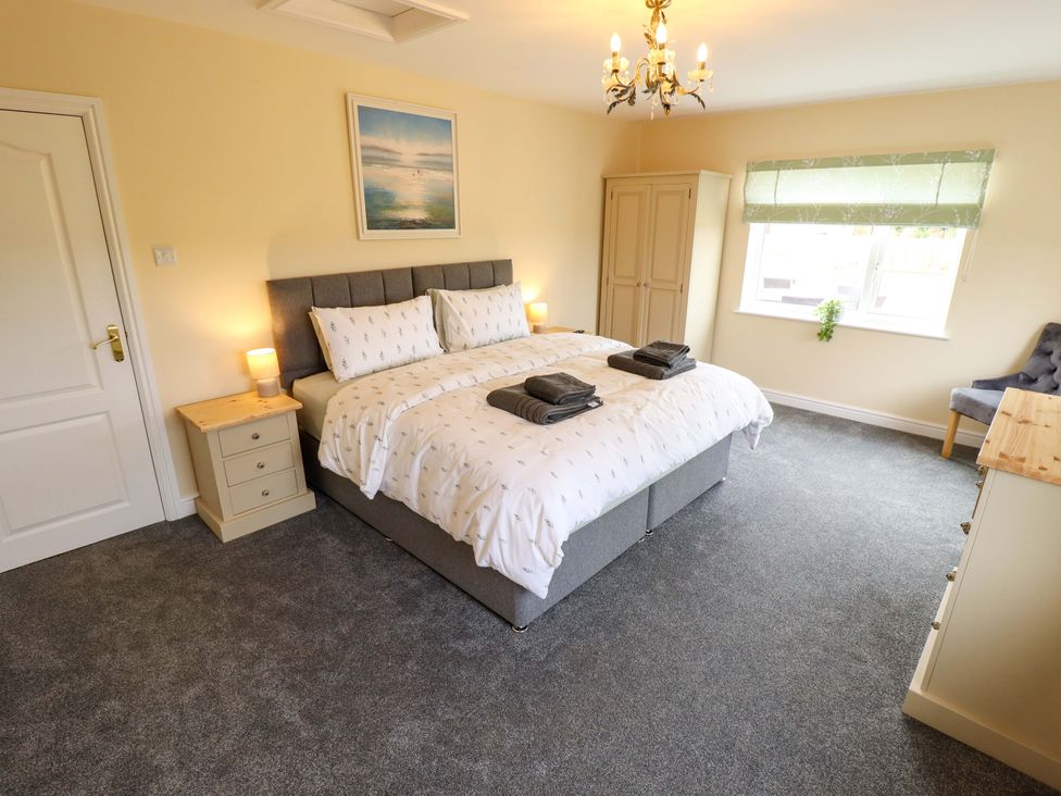 A bedroom with a double bed and wardrobe at Denholme in Hogsthorpe