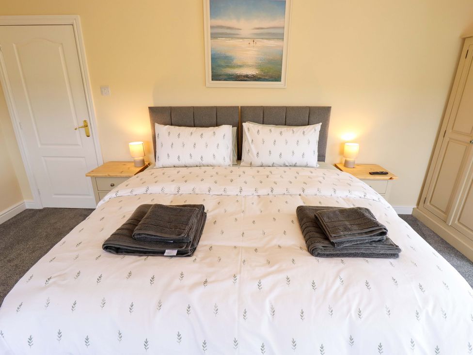 A bedroom with a double bed and nightstands at Denholme in Hogsthorpe
