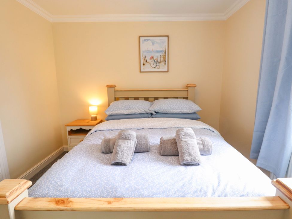 A bedroom with a bed and bedside table at Denholme in Hogsthorpe