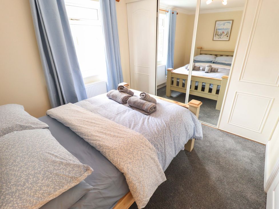 A bedroom with a bed and towels on the bed at Denholme in Hogsthorpe