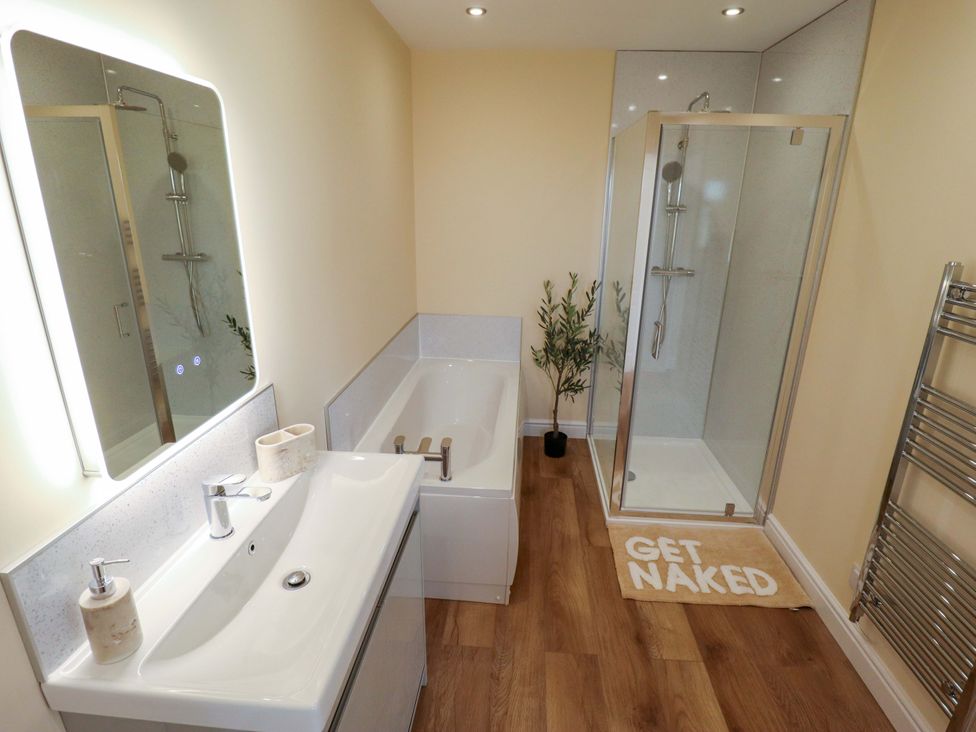 A bathroom with a bathtub and shower at Denholme in Hogsthorpe