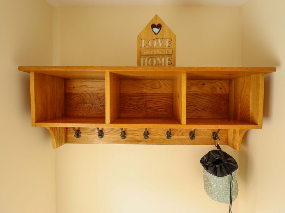 An entryway shelf with hooks and storage compartments at Denholme in Hogsthorpe