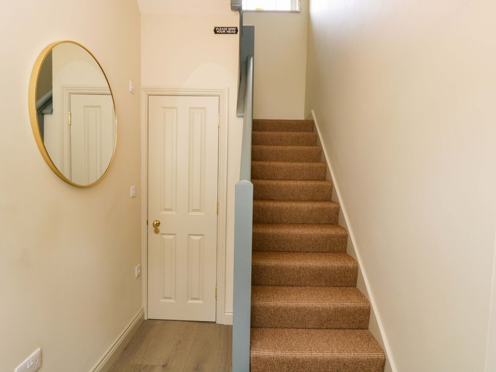 A hallway with a staircase and a mirror at Beech in Newbury