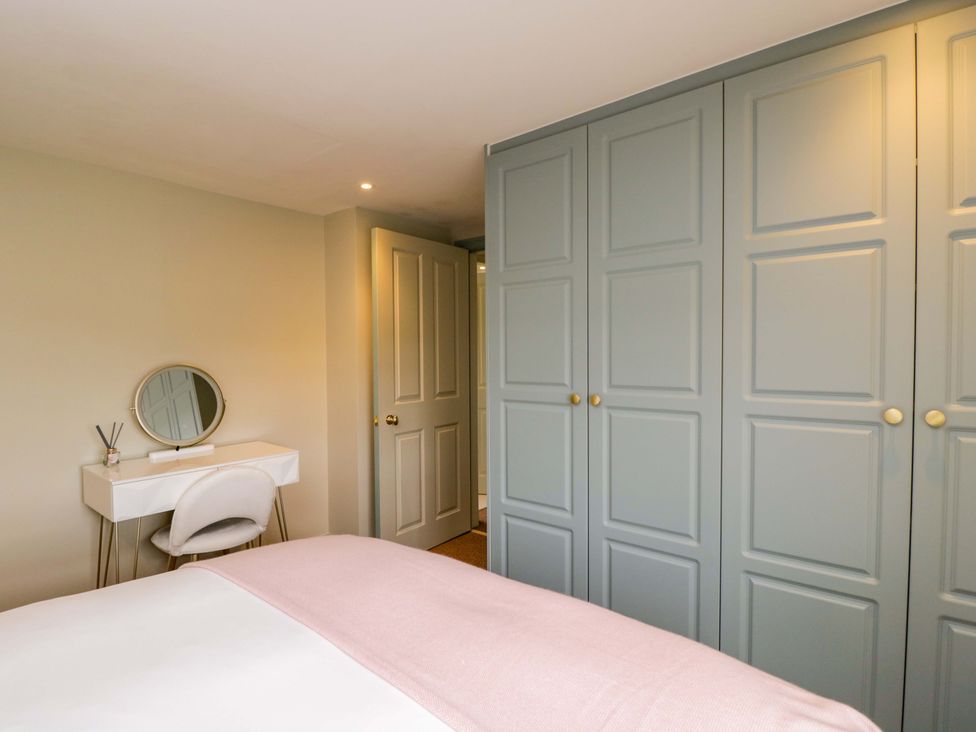 A bedroom with a bed and a vanity table at Beech in Newbury