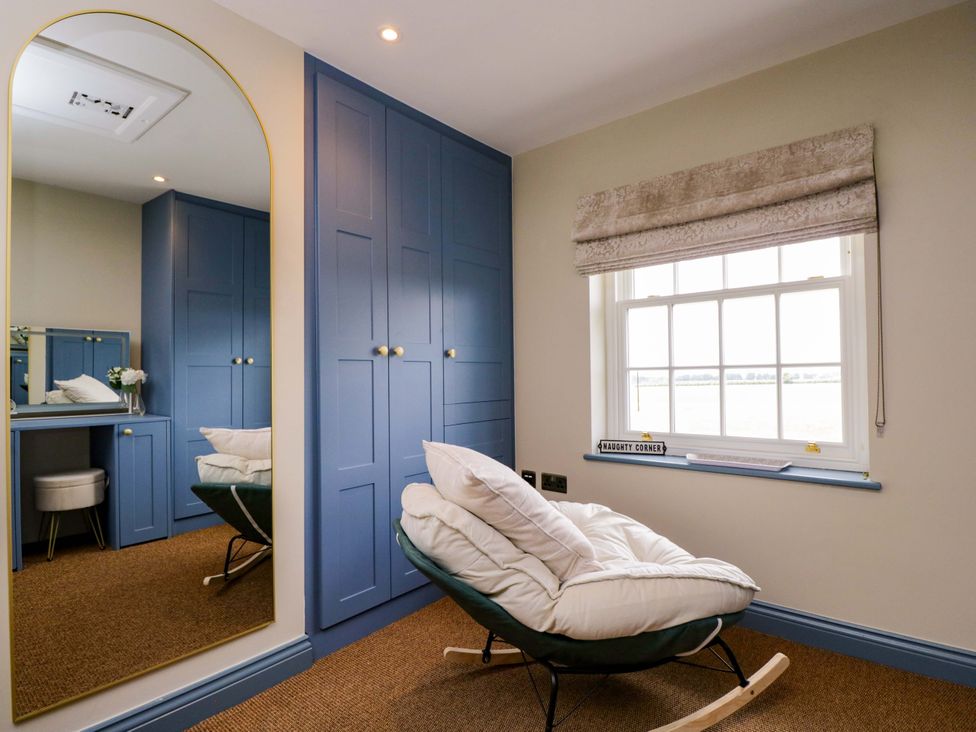 A bedroom with a rocking chair and a mirror at Beech in Newbury