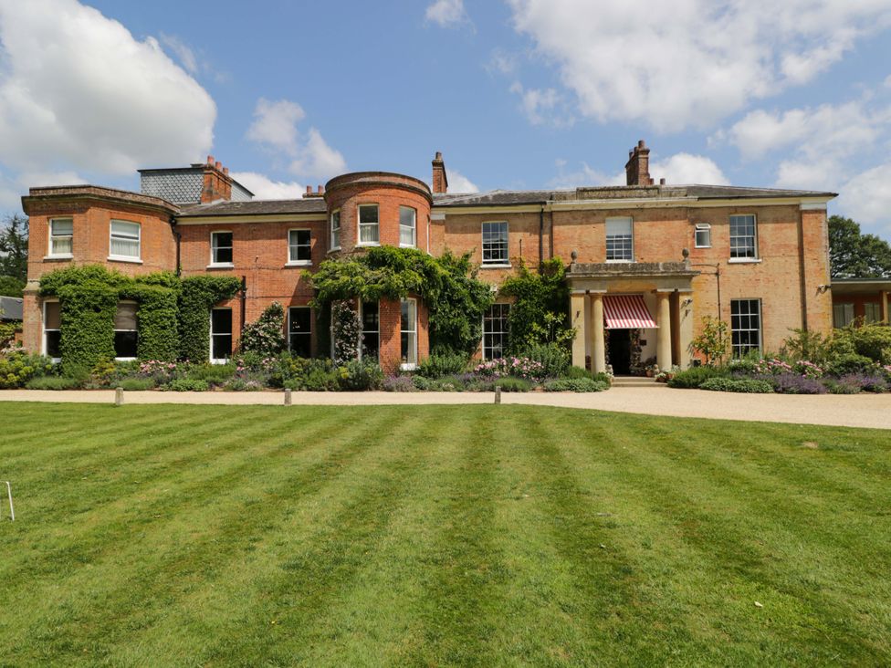 A garden view of a brick house with windows and a door at Beech in Newbury