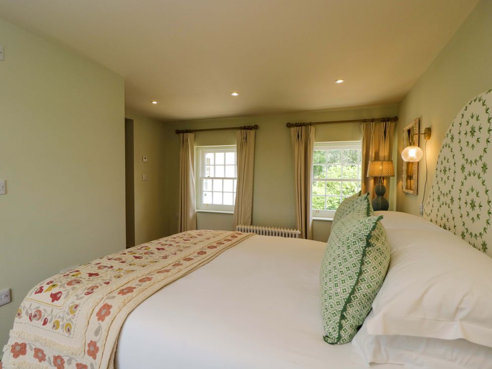 A bedroom with a bed and windows at Hazel in Elcot near Kintbury
