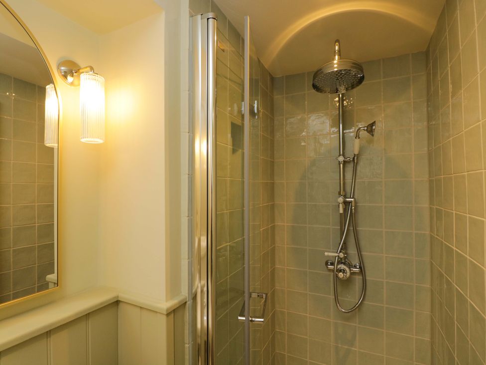 A shower with glass door and tile wall at Hazel in Elcot near Kintbury