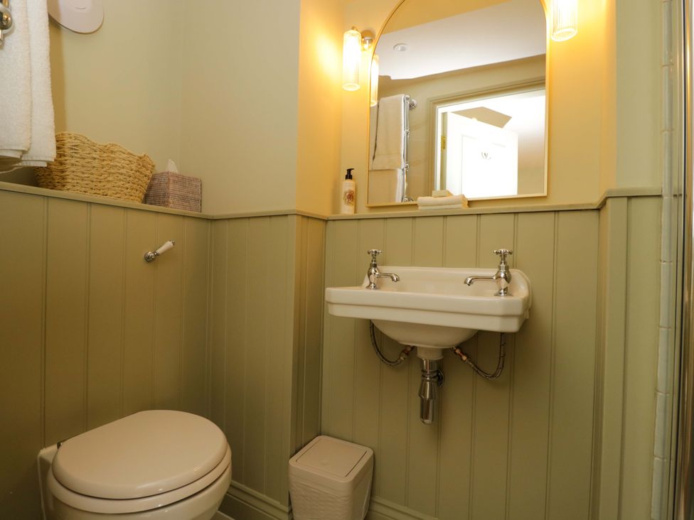 A bathroom with a sink, toilet, and mirror at Hazel in Elcot near Kintbury