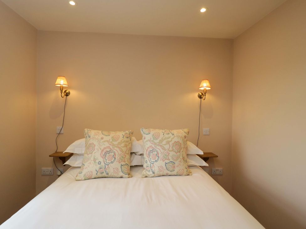 A bedroom with a bed and cushions at Hazel in Elcot near Kintbury