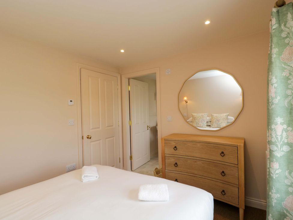 A bedroom with a bed and dresser at Hazel in Elcot near Kintbury