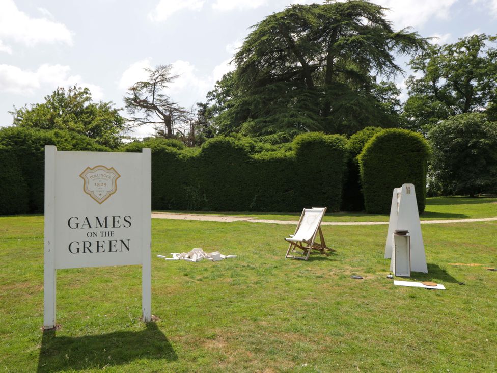 A sign for games on the green with chairs and equipment in the outdoor area at Hazel in Elcot near Kintbury