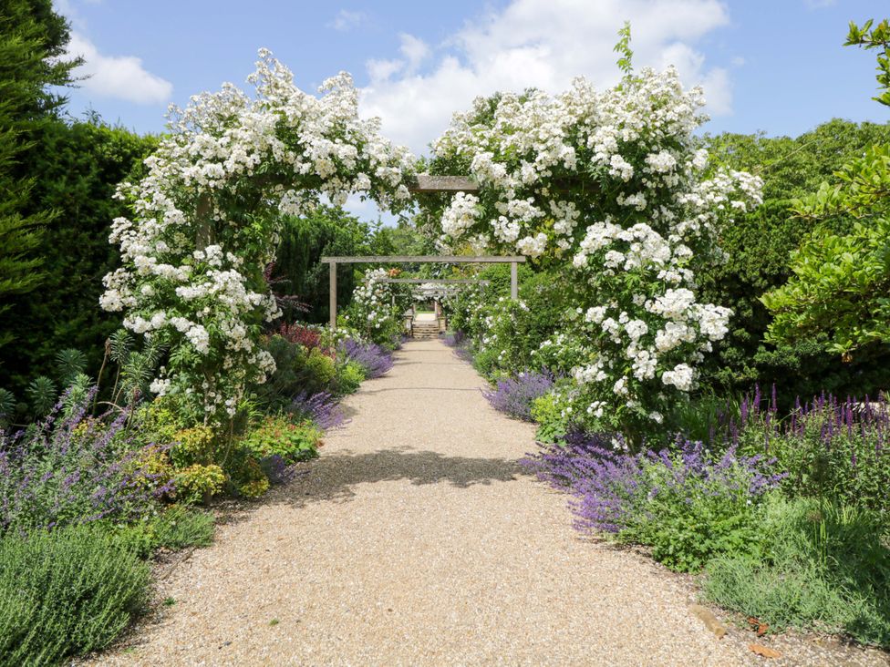 A garden pathway with flower arches at Hazel in Elcot near Kintbury