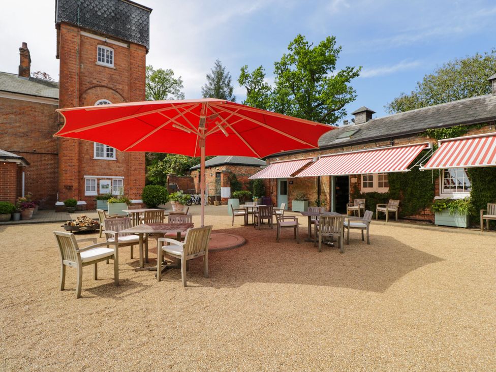 A garden area with seating and an umbrella at Hazel in Elcot near Kintbury
