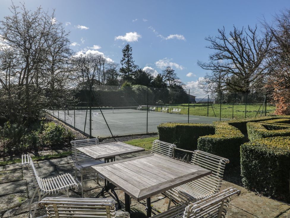 A tennis court with seating area at Hazel in Elcot near Kintbury