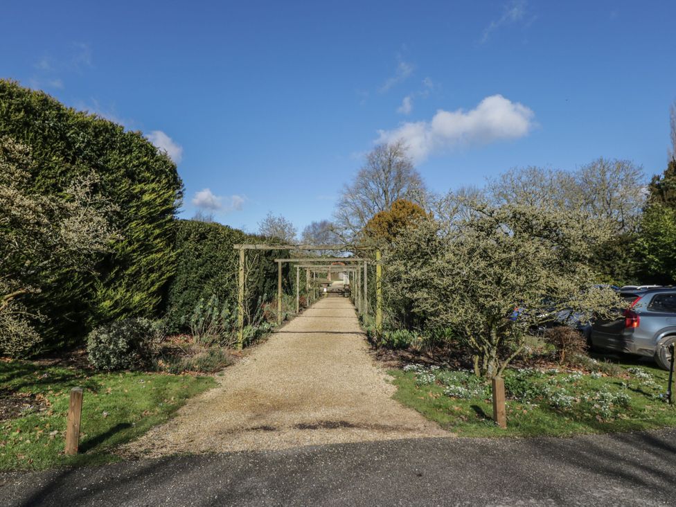 A garden pathway with trees and hedges at Hazel in Elcot near Kintbury