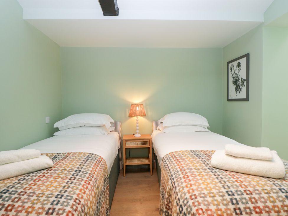 A bedroom with two single beds and a lamp at Cedar Elcot near Newbury