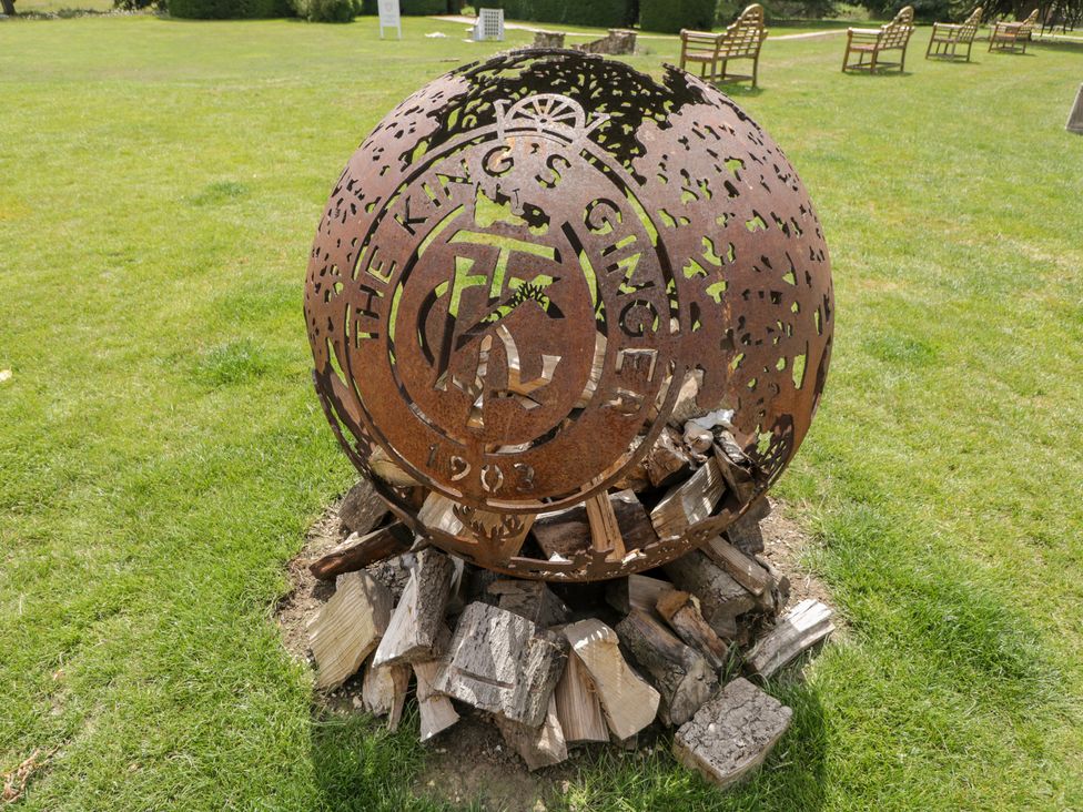 A metal sculpture on a wooden base in a garden at Cedar Elcot near Newbury